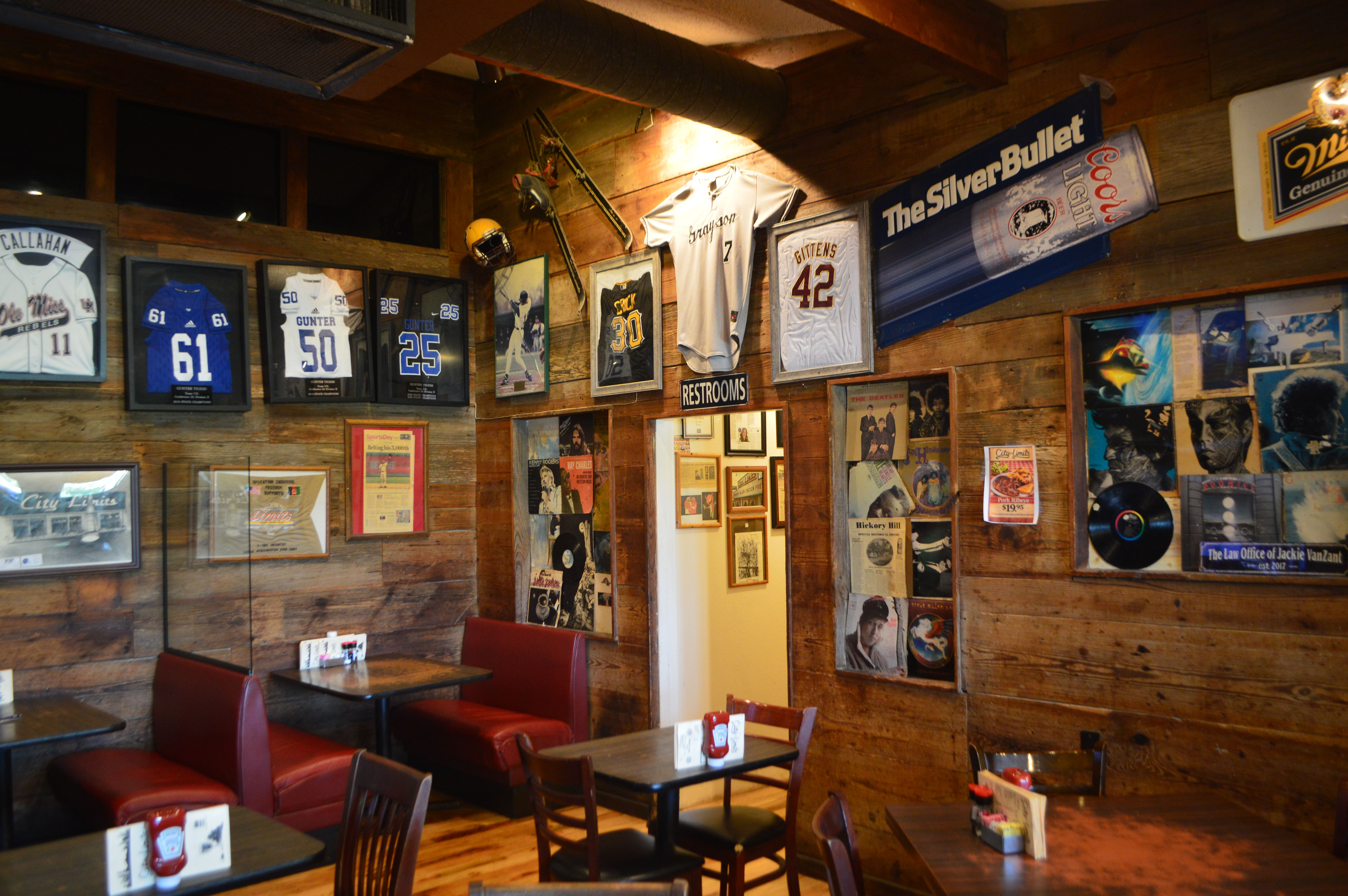 City Limits bar and grill interior — memorabilia wall with framed jerseys and records